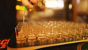 A skilled bartender meticulously fills shot glasses in a mesmerizing slow motion display of precision and artistry - Powered by Shutterstock - Get 15% off with code: PIKWIZARD15