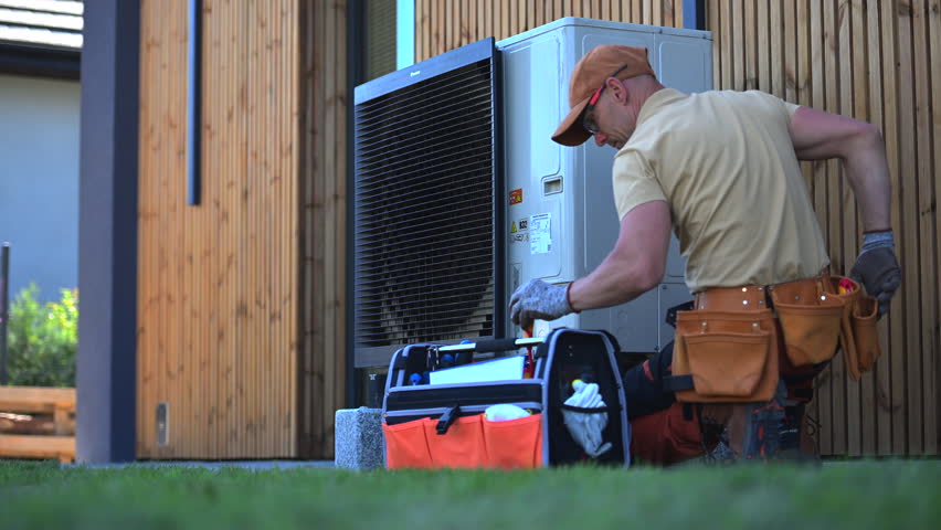 Technician Inspecting Outdoor Heat Pump Unit