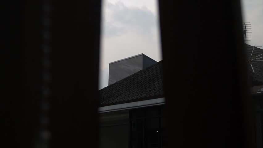 Video of the roof of a house in the middle of the afternoon with the sky starting to darken