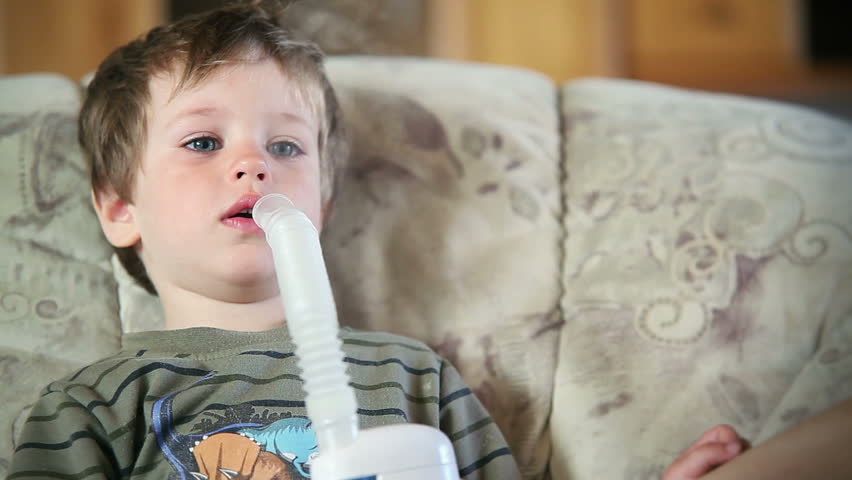 Little boy using nebulizer to inhale medicine, close up