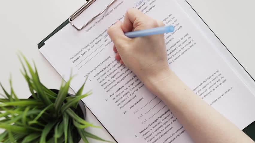 Intellectual property assignment agreement, hand fills out a document, trademark contract, brand authorization, business security