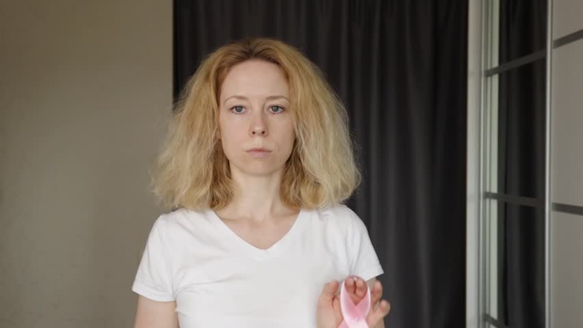 Breast cancer, woman with pink ribbon symbol at home, representing oncology and patient support.