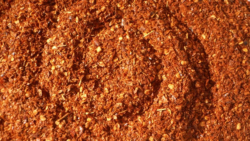 Zooming in on fiery ground chili, its vibrant red and earthy brown hues form a tapestry of spice. Flecks of seeds and flakes promise a flavor explosion, embodying the essence of heat.
