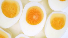 Sliced boiled eggs, each halved, exhibit vibrant yellow yolks encircled by resilient, snow-white egg whites. Their texture suggests firmness, indicative of a perfectly hard-boiled consistency.
 - Powered by Shutterstock - Get 15% off with code: PIKWIZARD15