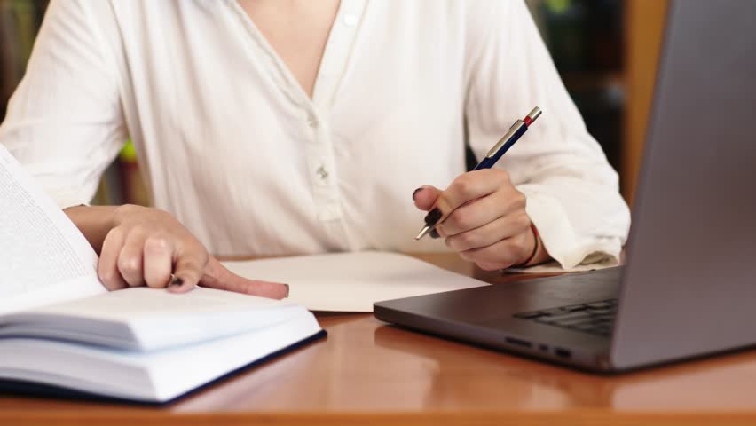 Close-up of a young girl student with a book in her hands. A sweet girl who is passionate about literature. Concept for exam preparation, scholarship and student life.