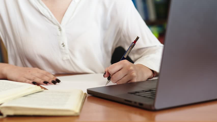 Close-up of a young girl student with a book in her hands. A sweet girl who is passionate about literature. Concept for exam preparation, scholarship and student life.