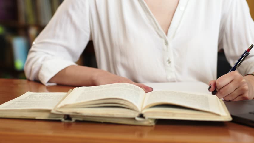 Close-up of a young girl student with a book in her hands. A sweet girl who is passionate about literature. Concept for exam preparation, scholarship and student life.