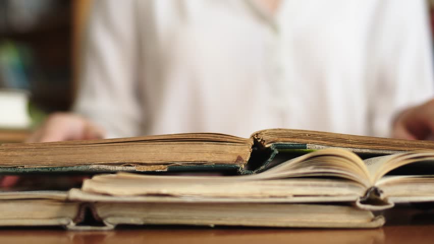Close-up of a young girl student with a book in her hands. A sweet girl who is passionate about literature. Concept for exam preparation, scholarship and student life.