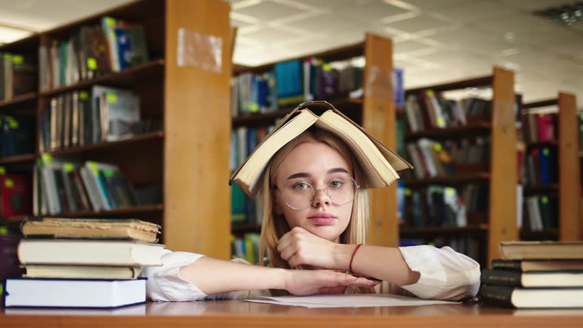 Close-up of a young girl student with a book in her hands. A sweet girl who is passionate about literature. Concept for exam preparation, scholarship and student life.