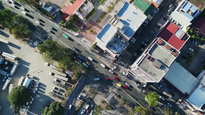 Aerial top-down view of a city intersection with heavy traffic and trucks parked in Metro Manila, Philippines