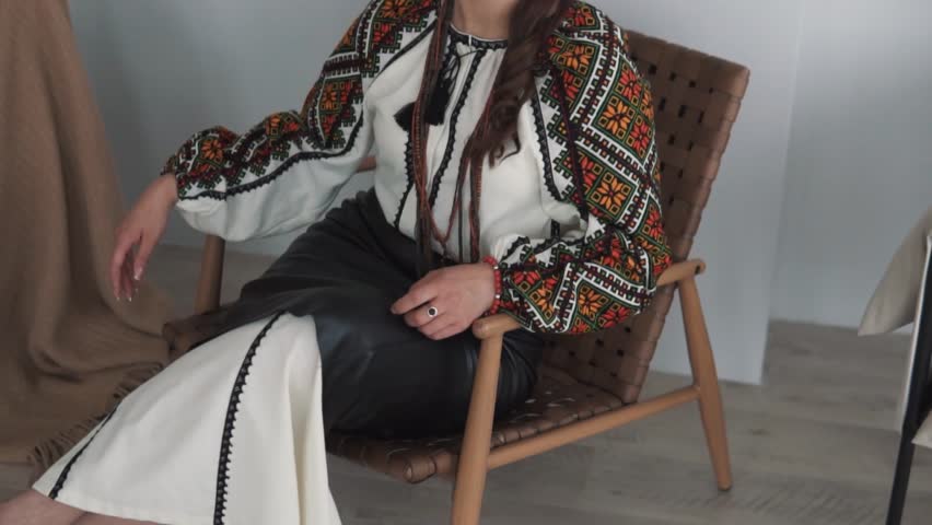portrait features a charming young woman in authentic embroidered Ukrainian attire posing and looking into the camera
