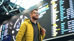 Passenger walk airport hall against FIDS. Male traveler check in trip. Guy fly away visit new city. Tourist man travel world. Happy person board plane. Train station arrival. Hipster hold backpack bag - Powered by Shutterstock - Get 15% off with code: PIKWIZARD15