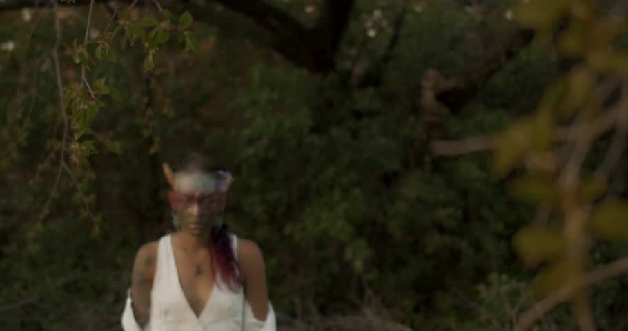Mystical Beltane face paint ritual in a forest at dusk as a young attractive woman wanders through a dimly lit forest at twilight, surrounded by lush greenery and a magical, hazy aura.