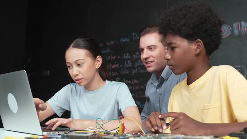 Caucasian teacher pointing at laptop while teaching about engineering code. Instructor working by using laptop while happy high school student learning and studying programming system. Edification - Powered by Shutterstock - Get 15% off with code: PIKWIZARD15