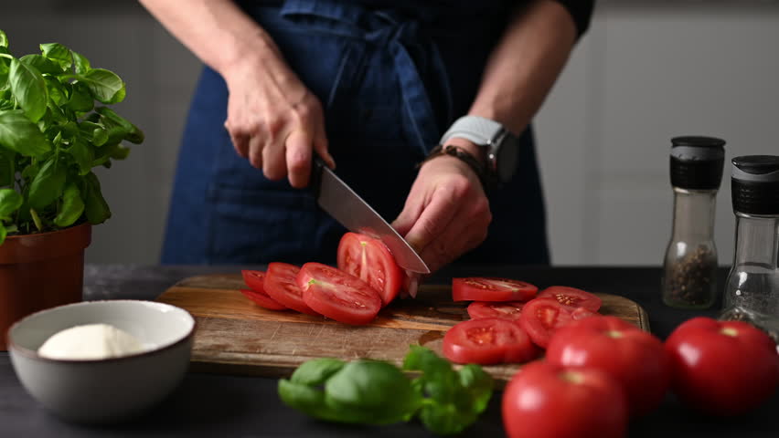 Girl Cutting Tomatoes For Caprese Salad In The Kitchen
