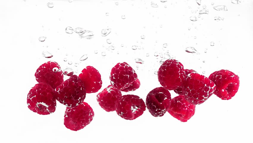 Ripe and delicious raspberries are falling and plunging into water filmed in slow motion against white background. Closeup view of fresh and sweet berries floating in aqua. Enjoying summer harvest - Powered by Shutterstock - Get 15% off with code: PIKWIZARD15