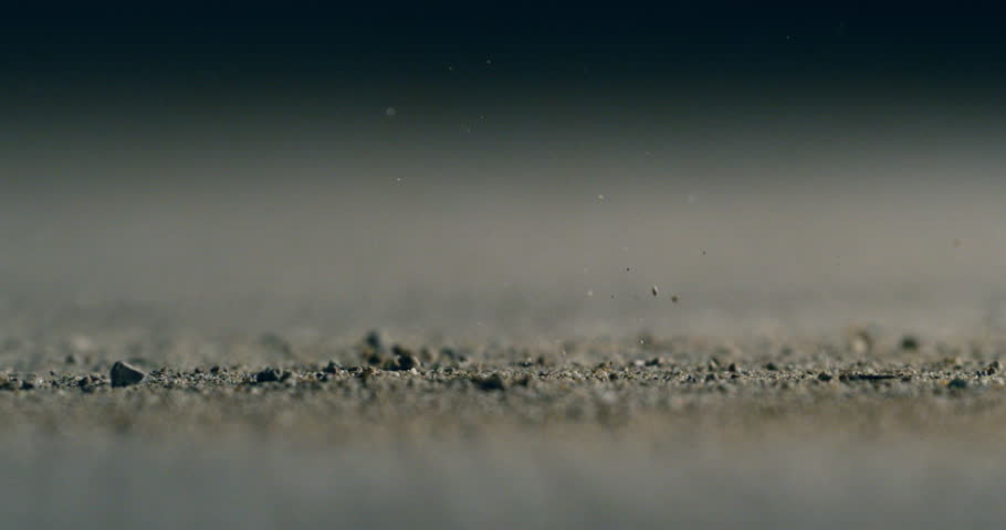 Super slow motion macro of bullet shell casings of machine fire gun falling down on ground with flying gunpowder during training in shooting range. Shooting and Weapons