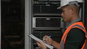 an asian man IT technician working on network Internet cables and servers and try to checklist on the clipboard to maintenance the data sharing network and all the cable, laptop, tablet, clipboard. - Powered by Shutterstock - Get 15% off with code: PIKWIZARD15