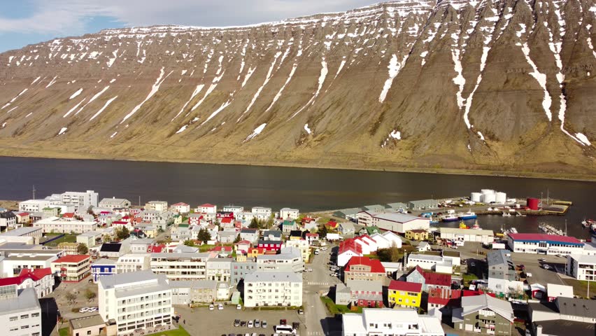 Aerial view of Isafjordur (Ísafjörður) and the harbour, Iceland, colorful buildings, sea, fjord, moutains with snow. Arctic climate, bright light. Polar climate. Westfjords region.	