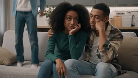 Stressed African American married couple tired mom dad sitting couch suffer naughty noisy shout little boy active son tantrum jump sofa house room. Unhappy female woman male man irritated by child kid - Powered by Shutterstock - Get 15% off with code: PIKWIZARD15