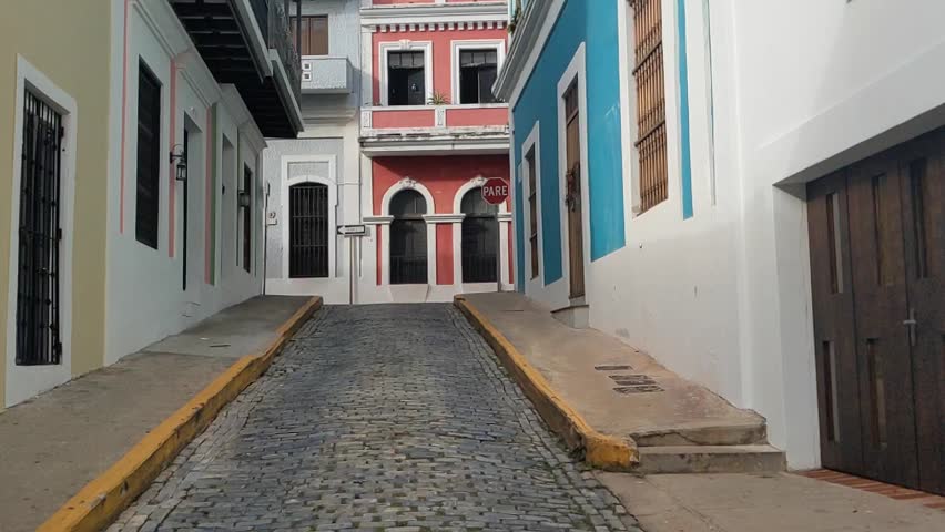 walking old san juan puerto rico (colorful colonial spanish style buildings) architecture historic beautiful color (colored homes downtown) blue cobblestone street travel tourism destination getaway
