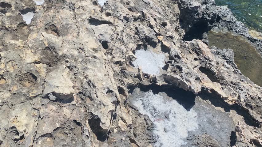 Eroded stone filled with sea salt , revealing Santa Maria Battery, comino island, Malta. High quality 4k footage