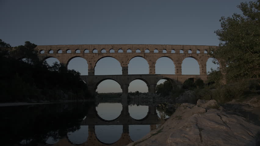 time lapse of the illuminated ancient Roman aqueduct Pont du Gard near Languedoc, France, built as part of the infrastructure for water supply of the roman empire.