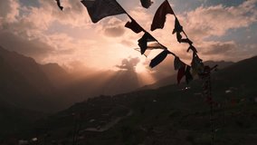 Slow motion shot of prayer flags waving in the wind in front of sunset sky in mountains during summer evening in Lahaul, Himachal Pradesh, India. Nature mountain landscape. Sunset view with cloudy sky - Powered by Shutterstock - Get 15% off with code: PIKWIZARD15