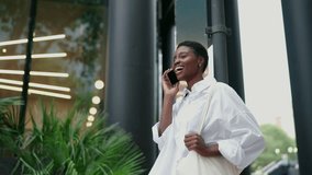 Happy African American female using modern communication, feeling joy of staying connected with loved ones or conducting business on the go. Cheerful black young woman have mobile phone call outdoors - Powered by Shutterstock - Get 15% off with code: PIKWIZARD15