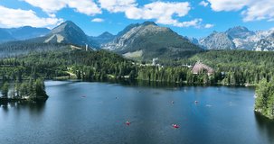 Summer landscape of a mountain lake on a sunny day. Location place Strbske pleso, High Tatras national park, Slovakia, Europe. Vibrant color drone video in 50fps. Discover the beauty of earth.