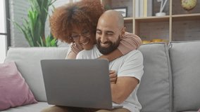 Interracial couple enjoying time together with laptop at home, showcasing love and technology - Powered by Shutterstock - Get 15% off with code: PIKWIZARD15