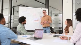 A charismatic mature male presenter leads a dynamic brainstorming session in a contemporary office setting, diverse team listens intently. A vibrant exchange of ideas and a culture of collaboration - Powered by Shutterstock - Get 15% off with code: PIKWIZARD15