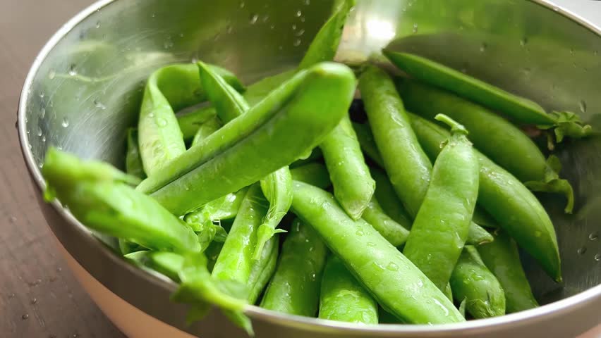 Green peas in pods in a bowl