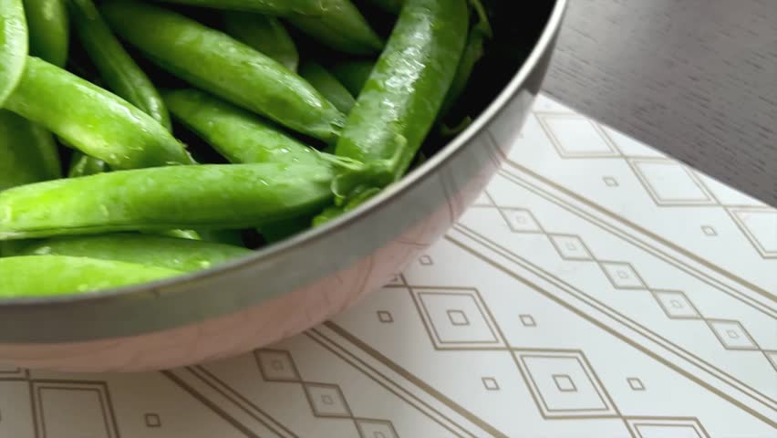 Green peas in pods in a bowl