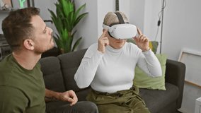 A woman wearing a vr headset interacts with virtual reality as a man watches her, both sitting in a modern living room. - Powered by Shutterstock - Get 15% off with code: PIKWIZARD15