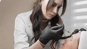 Professional aesthetician with black gloves performs Botox injection on clients forehead in a spa clinic. This closeup procedure is part of a beauty treatment for antiaging skin care - Powered by Shutterstock - Get 15% off with code: PIKWIZARD15
