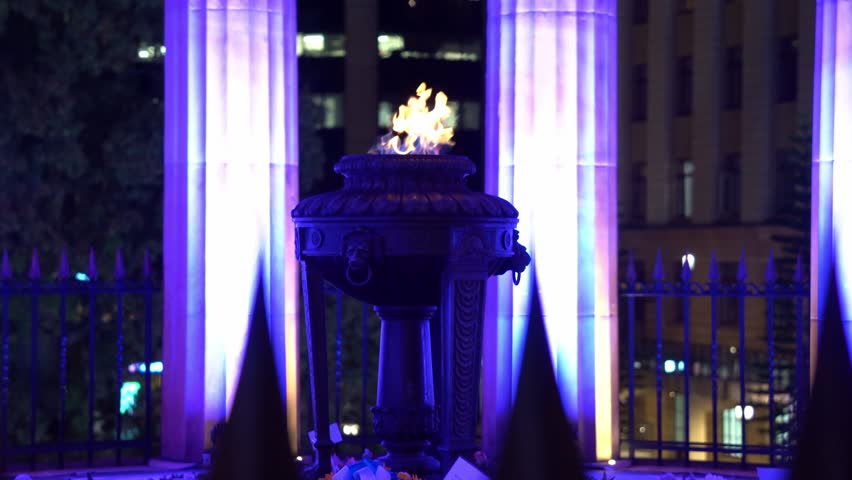 Shrine of remembrance and eternal flame burning at its heart, Anzac Square war memorial parklands at Brisbane city, Queensland, Australia, handheld motion shot.