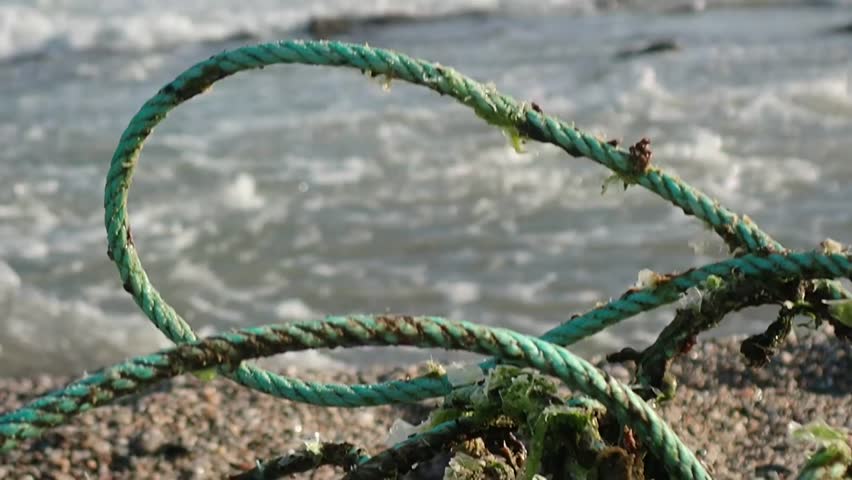 Abandoned gallows-shaped nets symbolizing the countless deaths caused by ghost nets. Close-up focus on the rope. A lost fishing net on the shore of the Mediterranean Sea.