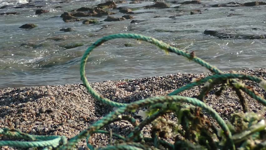Fishing rope abandoned near Cabo de Gata-Níjar Natural Park and Marine Reserve in the shape of a gallows symbolizing the deadly danger of ghost nets to marine life. Close-up focus on the sea.