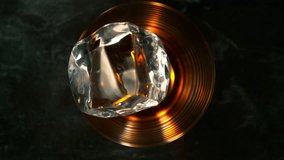 Super Slow Motion Shot of Ice Cube Falling into Glass with Alcohol at 1000fps with Camera Motion. - Powered by Shutterstock - Get 15% off with code: PIKWIZARD15