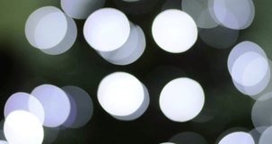 White bokeh lights softly sparkle and fade against a neutral backdrop, creating a festive and elegant ambiance. This video clip is ideal for holiday or seasonal projects, adding a touch of magic.