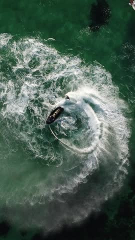A man flies on a FlyBoard. Aerial top down view. Water extreme sport, azure summer sea with outdoors active people enjoying water sports. Flyboarding and seariding, Recreation and sports concepts.
