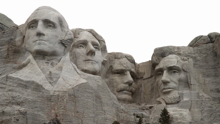 Mount Rushmore and the sculpted heads of Presidents Washington, Jefferson, Roosevelt and Lincoln. The cloudy day brings a unique atmosphere to the monument, adding depth to this historic marvel.