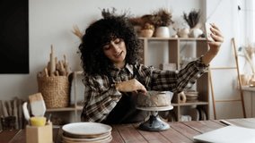 Female potter recording vlog in studio while sculpting clay. - Powered by Shutterstock - Get 15% off with code: PIKWIZARD15