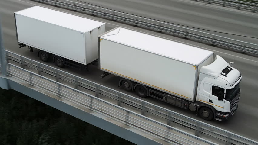 Long distance truck freight. Big lorry cargo transportation drone view from above. Large van drive city street highway. Road way logistic. Fast heavy semi trucks goods delivery. Trucker driver move.