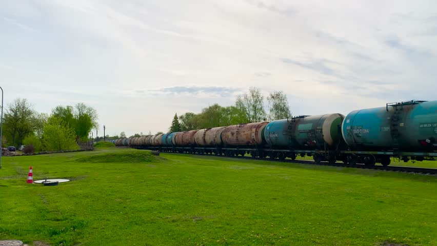 Static shot of long line of freight train cisterns transport diesel fuel, Latvia