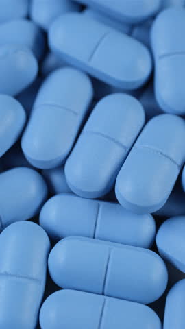 Heap of blue pills close up, slider shot. Pharmaceutical Industry