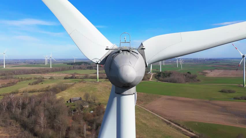 Close-up shot of energy producing wind turbine in a vast field on a sunny day in Taurage, Lithuania