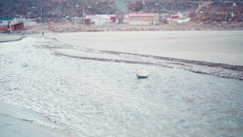 Toy dump truck floats away on a beautiful beach in Northern Norway right outside of Tromso, Norway. With big mountains in the background, a stunning capture. #untraceableglobal