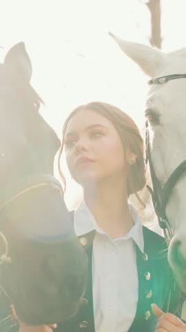 Close-up person beauty face eyes lips woman with horse, fantasy girl princess noble lady looking at camera, love affection emotion. two horses animal muzzle pet. sun light flare. vertical video crop